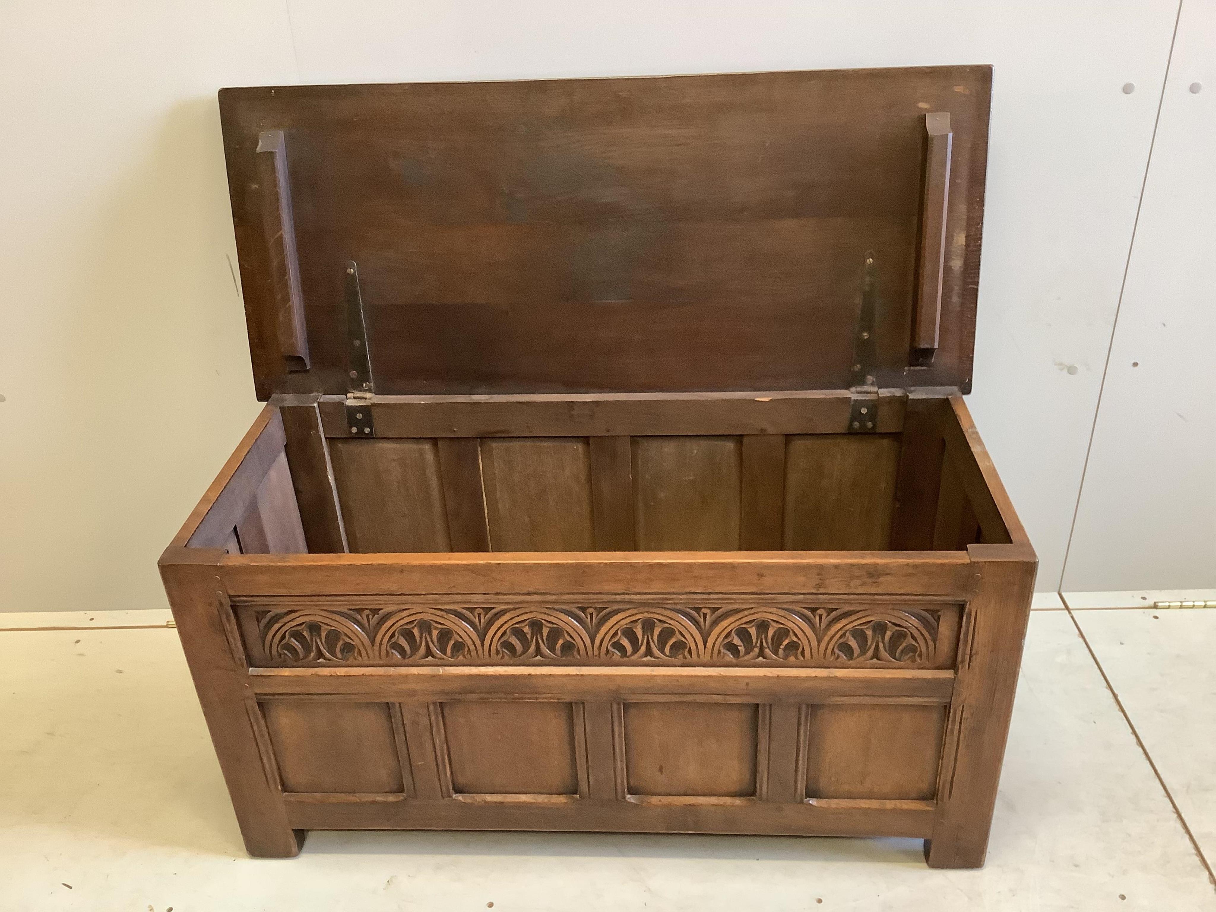 A reproduction 18th century style carved oak coffer, width 106cm, depth 46cm, height 54cm together with an elm and beech Windsor elbow chair. Condition - fair